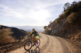 lael Wilcox rides on a gravel path