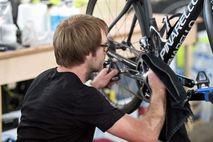 Man making adjustments to bicycle